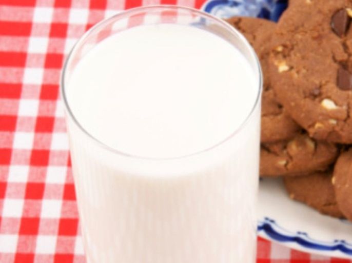Glass cup of milk and cookies on tablecloth
