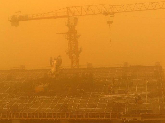 Construction workers are seen amid a sandstorm at one of construction sites in Dubai, United Arab Emirates, 02 April 2015. A dust storm, affecting different Gulf countries, caused low visibility across the UAE and disrupted air traffic.