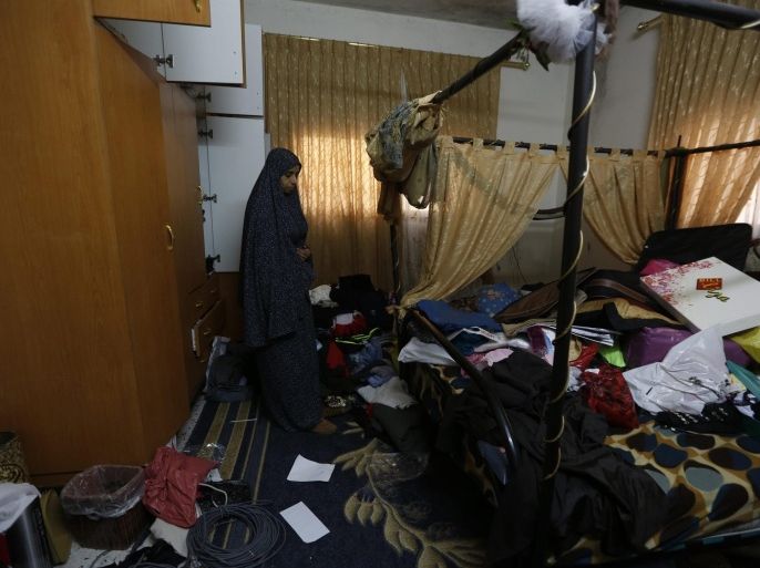 Wife of Palestinian Jaser Abu Hamada checks the damage in a room of her home after Israeli troops searched the house after the arrest of her husband at Balata refugee camp near the West Bank city of Nablus, 15 April 2015. Dozens of Israeli military vehicles entered the northern West Bank city of Nablus, searching homes, seizing items and arresting 30 Palestinians, Palestinian security officials said.