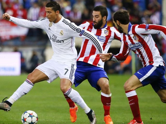 Atletico Madrid's Turkish midfielder Arda Turan (C) and defender Juanfran (R) vie for the ball with Real Madrid's Portuguese striker Cristiano Ronaldo during the UEFA Champions League quarter final first leg soccer match between Atletico Madrid and Real Madrid at Vicente Calderon stadium, in Madrid, Spain, 14 April 2015.