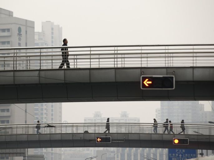 People walk on bridges during a hazy day in downtown Shanghai January 30, 2015. China's pollution crisis has inspired an environmental regulator in a smog-blanketed northern province to write a novel whose extracts have gone viral online, spurring plans for two more books. "Smog Is Coming", published last June, touches on fraud and bureaucracy and their impact on air pollution, with the official China Daily reporting that online excerpts have received tens of millions of pageviews. REUTERS/Aly Song (CHINA - Tags: SOCIETY ENVIRONMENT POLITICS)