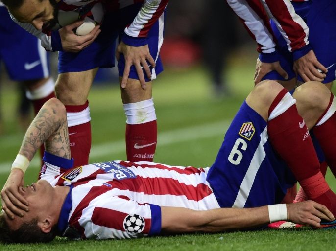 Atletico Madrid's Croatian forward Mario Mandzukic lies on the ground after bing injured during the UEFA Champions League football match Club Atletico de Madrid vs Bayer Leverkusen at the Vicente Calderon stadium in Madrid on March 17, 2015. AFP PHOTO / JAVIER SORIANO