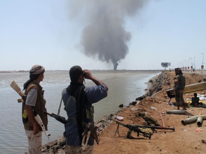 Smoke billows on the horizon as supporters of exiled Yemeni President Abedrabbo Mansour Hadi block a road in al-Mansura, east of the southern Yemeni city of Aden, as they try to make advances on the Khor Maskar area of the city held by Shiite-Huthi rebels on April 29, 2015. AFP PHOTO / SALEH AL-OBEIDI