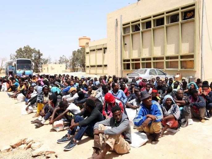 Migrants from sub-Saharan Africa sit at a center for illegal migrants in the al-Karem district of the Libyan eastern port city of Misrata on May 9, 2015, as they wait to be transported to a different detention center. Mohammed Khalifa al-Guwail, the acting prime minister of Libya's disputed government, urged European Union countries to help his administration tackle illegal immigration by sending boats for the coastguard. AFP PHOTO / MAHMUD TURKIA