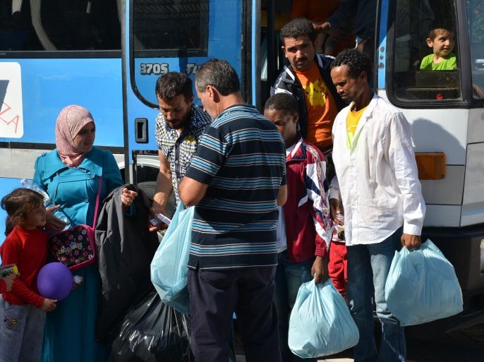 لاجئون سوريون وأريتريون عند وصولوهم لمركز اللجوء بجزيرة لامبيدوزا الإيطالية . الجزيرة نت