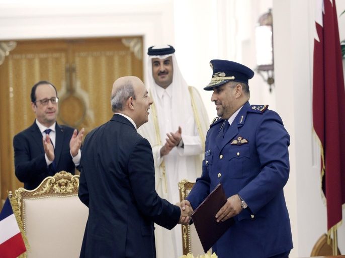 French President Francois Hollande (L) and Qatar's Emir Sheikh Tamim bin Hamad al-Thani,(behind R), applaud while Eric Trappier, (front L) head of Dassault Aviation shakes hands with Qatar's Gen. Ahmad Al-Malki after signing the agreement at the Diwan Palace in Doha, on May 4, 2015. Hollande arrived in Qatar to oversee the signing of a multi-billion-euro deal to sell 24 Rafale fighter jets to the gas-rich emirate. AFP PHOTO/ POOL / CHRISTOPHE ENA