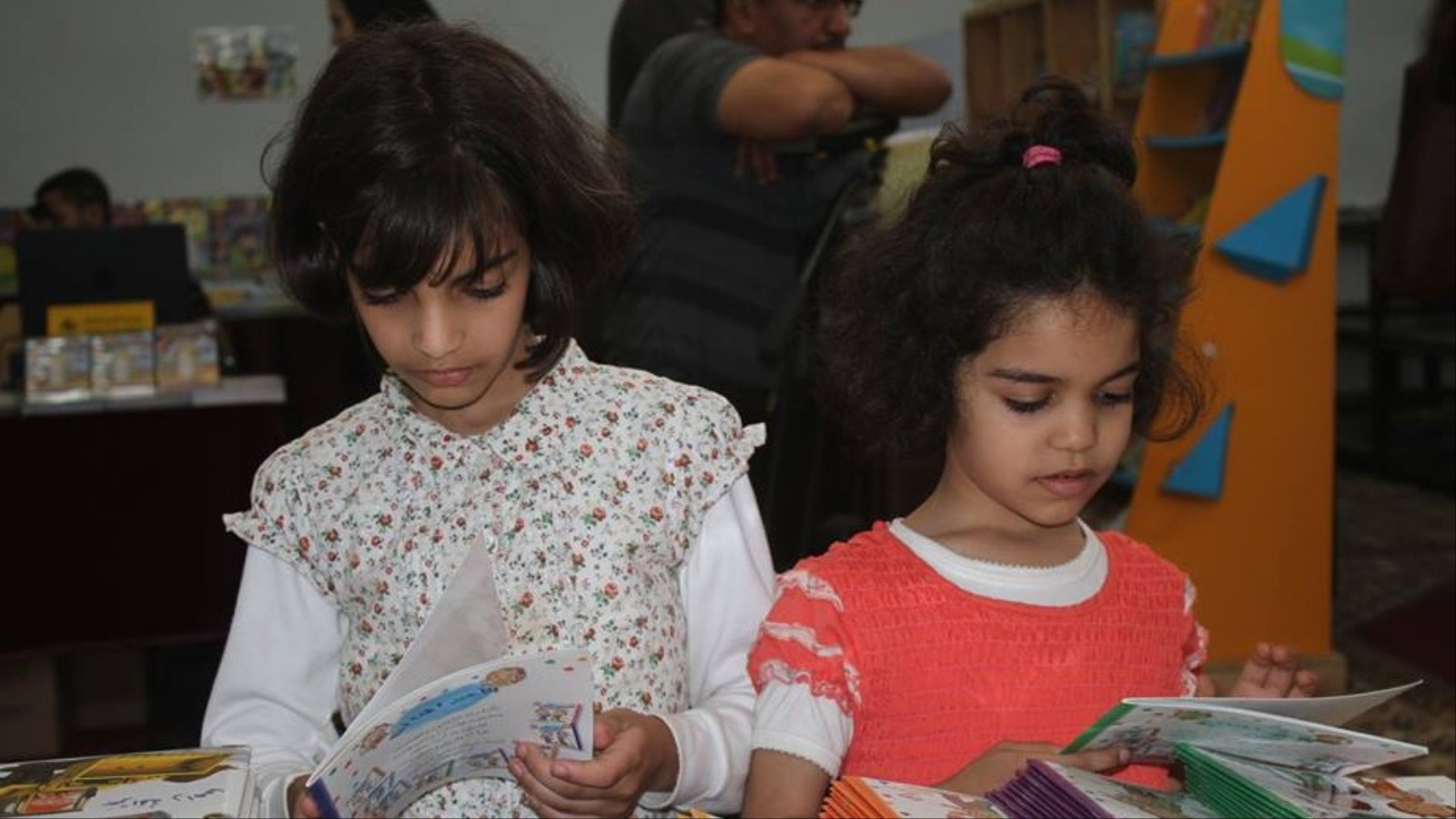‪طفلتان تطالعان في معرض كتاب الطفل بالمغرب‬ (الجزيرة)