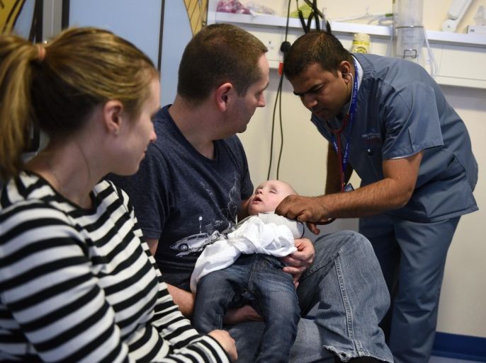 A doctor attends to a young patient in the specialist Children's Accident and Emergency department of the 'Royal Albert Edward Infirmary' in Wigan, north west England on April 2, 2015. British Prime Minister David Cameron kicked off his re-election campaign Saturday, March 28, 2015, for May's tight poll by echoing his main rival with a new promise to improve the state-run National Health Service (NHS). Polling by Ipsos MORI indicates that the NHS, which provides across-the-board care for Britons and is mostly free, is the most important issue for voters. AFP PHOTO / OLI SCARFF