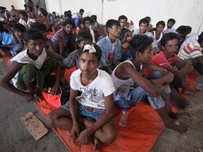 Newly arrived Rohingya migrants sit inside a temporary shelter at Kuala Langsa Port in Langsa, Aceh province, Indonesia, Friday, May 15, 2015. Hundreds of Bangladeshi and ethnic Rohingya migrants have landed on the shores of Indonesia and Thailand after being adrift at sea for weeks, authorities said Friday. They are among the few who have successfully sneaked past a wall of resistance mounted by Southeast Asian countries who have made it clear the boat people are not welcome. (AP Photo/Binsar Bakkara)