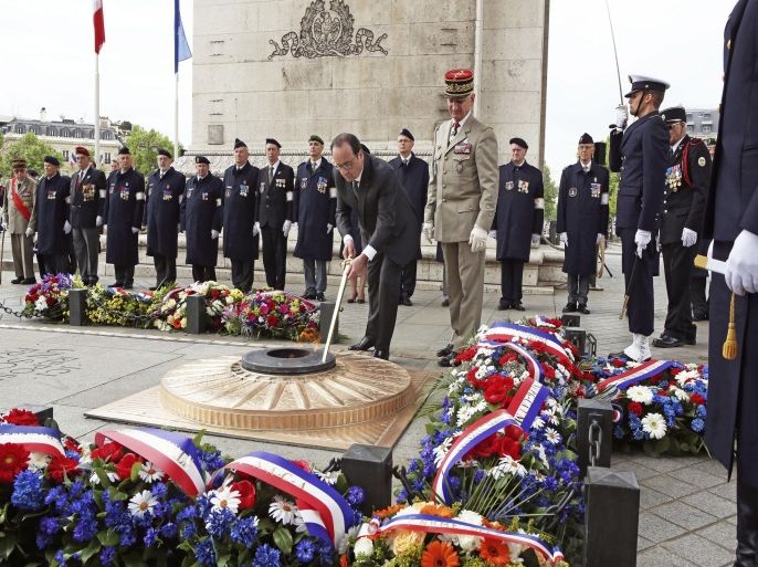 French President Francois Hollande (Foreground) re-kindles the eternal flame at the Tomb of the Unknown Soldier a ceremony at the Arc de Triomphe in Paris on May 8, 2015, during a ceremony to mark 70 years since victory over Nazi Germany during World War II. Europe held sombre ceremonies to mark 70 years since victory over Nazi Germany on May 8 as leaders warned of modern day threats such as the war in Ukraine and Islamic extremism. AFP PHOTO / POOL / REMY DE LA MAUVINIERE