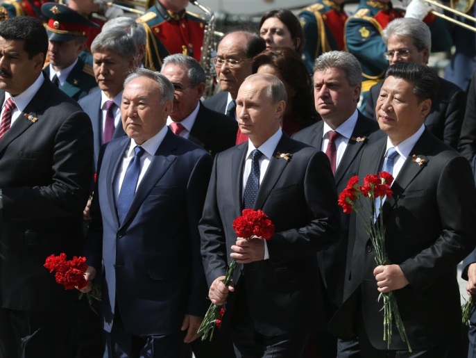 ‪بوتين مع بعض ضيوفه خلال وضع أكاليل‬ (غيتي)