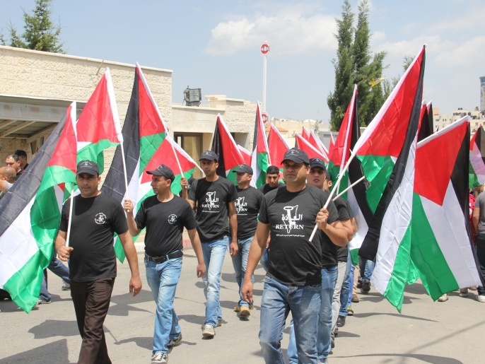 المشاركون بالمسيرة حملوا الأعلام الفلسطينية (الجزيرة نت)