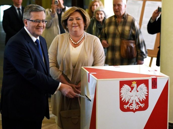 Polish President and presidential candidate Bronislaw Komorowski (L) with his wife Anna (R) casts his vote in the presidential election run-off at a polling station in Warsaw, Poland. In the first round earlier this month neither Conservative challenger Andrzej Duda nor incumbent Bronislaw Komorowski gained the 50 per cent needed to win outright. EPA/Radek Pietruszka POLAND OUT