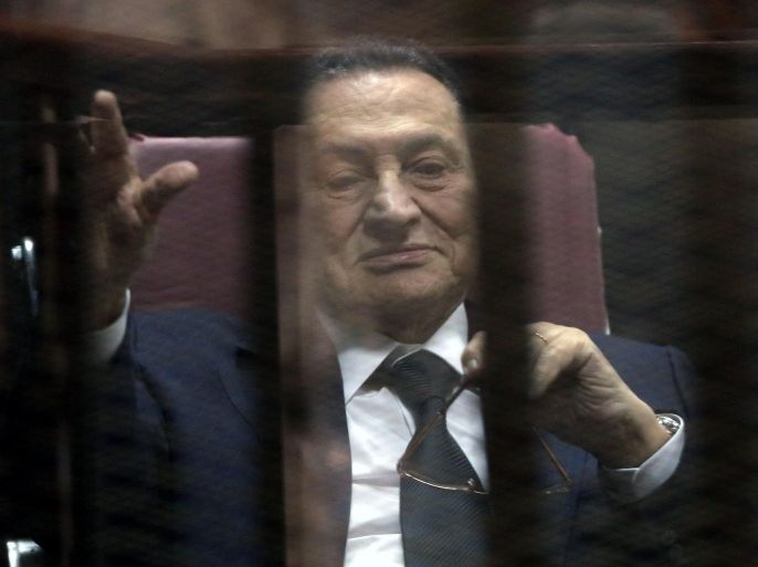 Former Egyptian President Hosni Mubarak waves from defendants' cage at a courtroom during his trial in Cairo, Egypt, 29 April 2015. Mubarak appeared in the retrial session on charges of fraudulently spending millions of dollars on his private residences. A court on 21 May 2014 handed Mubarak a three-year jail sentence in the case.