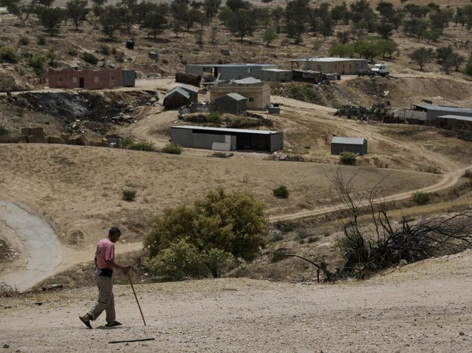 In this Tuesday, May 12, 2015 photo, a Bedouin man walks through the village of Umm Al-Hiran in the Negev desert, Israel. In a landmark decision, Israel's Supreme Court has cleared the way for the government to uproot the nearly 60-year-old Bedouin Arab village of Umm al-Hiran, a dusty hill of ramshackle dwellings without proper electricity or water hookups, and in its place build "Hiran," a new Jewish community expected to feature a hotel and country club. (AP Photo/Tsafrir Abayov)