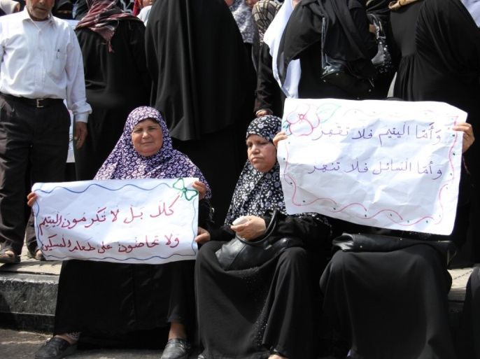 فلسطين غزة - مايو 2015 - نسوة يحملن لافتات احتجاج بنك فلسطين بعد تجميده حسابات لجمعيات خيرية