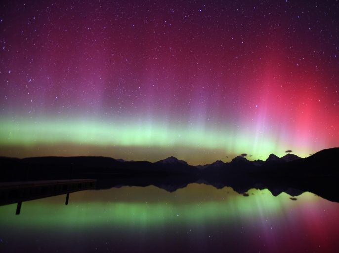 In this Thursday, April 9, 2015 photo, an aurora borealis (northern lights) illuminates the night sky over Lake McDonald in Glacier National Park, Mont. at 11:56 p.m. The shimmering is caused by an interaction of a solar storm with the earth's electromagnetic field. (AP/Daily Inter Lake, Brenda Ahearn)