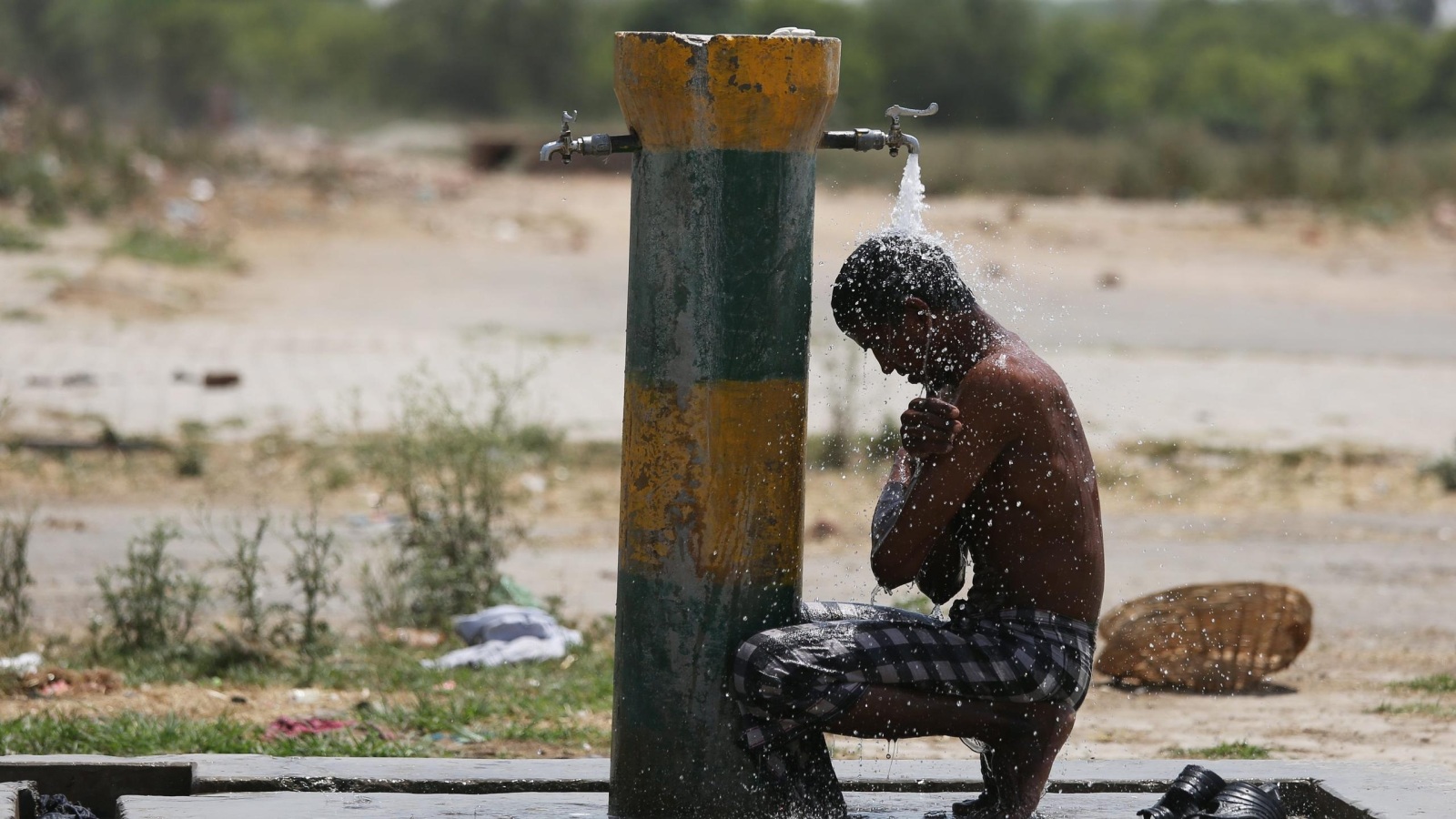 شاب هندي يلوذ بماء حنفية في ظهيرة شديدة الحرارة خلال أسبوع شهد مقتل أكثر من 800 شخص بسبب موجة الحر