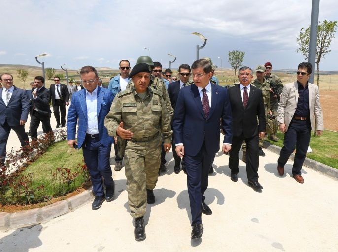 SANLIURFA, TURKEY - MAY 10: Turkish Prime Minister Ahmet Davutoglu (front R) visits the Tomb of Suleyman Shah in the Turkey's exclave inside the Ashme region of Aleppo on May 10, 2015. On Feb. 22, Turkey made a two-pronged operation and brought the remains of Suleyman Shah and sacred relics to Ashme, located 200 meters south of the Turkish-Syrian border, from the original exclave in Syria, some 37 kilometers away from the border, to Turkey.