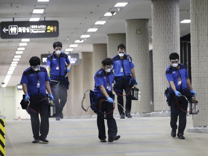 Workers wearing masks and goggles, spray disinfectant as a precaution against the spread of Middle East Respiratory Syndrome virus at Gimpo International Airport in Seoul, South Korea Wednesday, June 17, 2015. The South Korea's MERS outbreak originated from a 68-year-old man who had traveled to the Middle East, where the illness has been centered, before being diagnosed as the country's first MERS patient last month. (AP Photo/Lee Jin-man)
