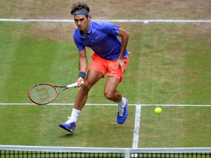 Roger Federer of Switzerland returns the ball to Ivo Karlovic of Croatia during their semi final match of the ATP tennis tournament in Halle, Germany, 20 June 2015.