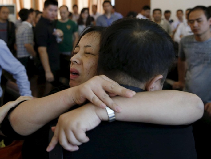 رجل يساعد امرأة منهارة خلال مؤتمر صحفي للحكومة بسبب فقدان أحد أفراد أسرتها إثر غرق السفينة الصينية (رويترز)