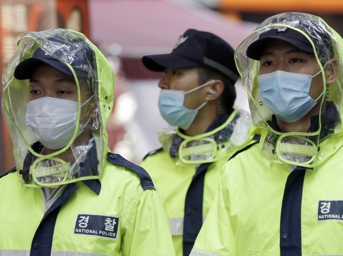 South Korean police officers wear masks as a precaution against MERS (Middle East Respiratory Syndrome) at a shopping district in Seoul, South Korea, Friday, June 5, 2015. Sales of surgical masks surge amid fears of a deadly, poorly understood virus. Airlines announce "intensified sanitizing operations." More than 1,100 schools close and 1,600 people — and 17 camels in zoos — are quarantined. The current frenzy in South Korea over MERS, or Middle East Respiratory Syndrome, brings to mind the other menacing diseases to hit Asia over the last decade — SARS, which killed hundreds, and bird flu. (AP Photo/Lee Jin-man)