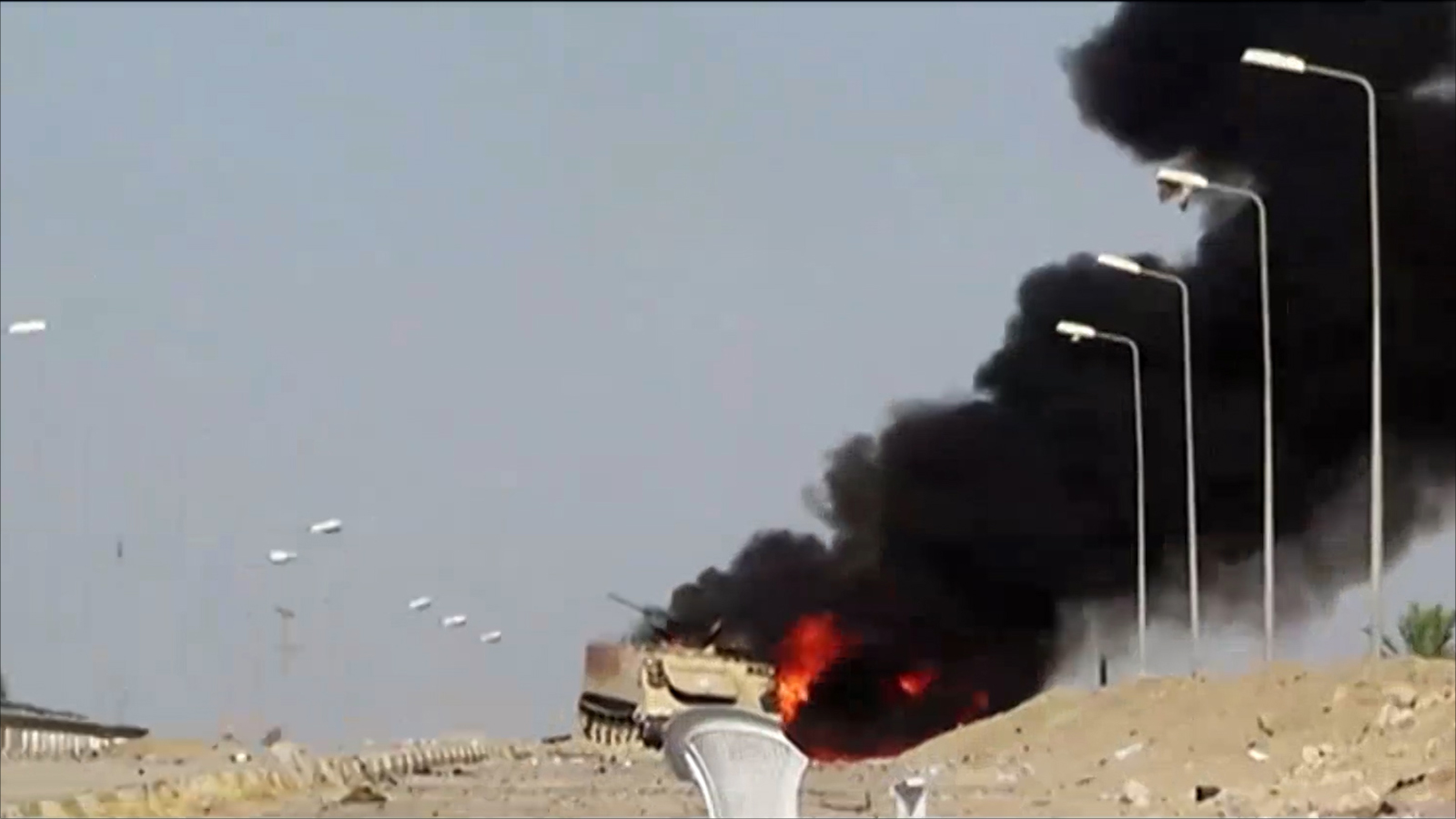 ‪آلية للجيش العراقي احترقت إثر هجوم سابق لتنظيم الدولة في محافظة الأنبار‬ (الجزيرة-أرشيف)