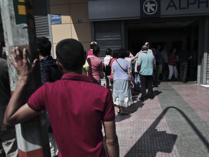 Greeks queue to withdraw cash from an Alpha Bank ATM in central Athens on June 28, 2015. The ECB pledged continued emergency cash for Greece, but no extra help to guard against a feared bank run that could set off financial chaos leading to a euro exit. As the Greek crisis spiralled after talks between Athens and its creditors broke down, Greek citizens have queued at bank machines, heaping pressure on the government to impose capital controls. AFP PHOTO / ANGELOS TZORTZINIS