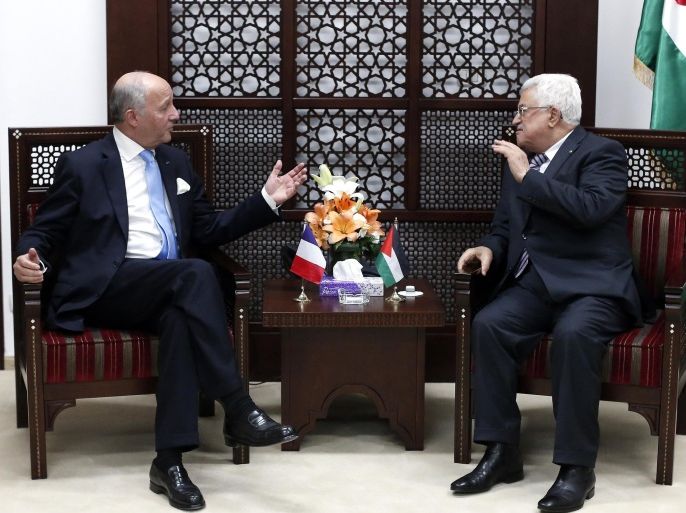 French Foreign minister Laurent Fabius (L) gestures as he is received by Palestinian president Mahmud Abbas at the Mukataa compound in the West Bank city of Ramallah, on June 21, 2015. Fabius, during a visit to Cairo earlier in the week, urged the resumption of Middle East peace talks, while warning that continued Israeli settlement building on land the Palestinians want for a future state would damage chances of a final deal. AFP PHOTO / POOL / THOMAS COEX