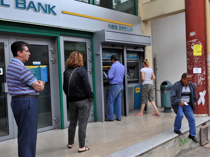 ‪عقب الدعوة للاستفتاء تهافت اليونانيون لسحب أموالهم من البنوك‬ (غيتي/الفرنسية)