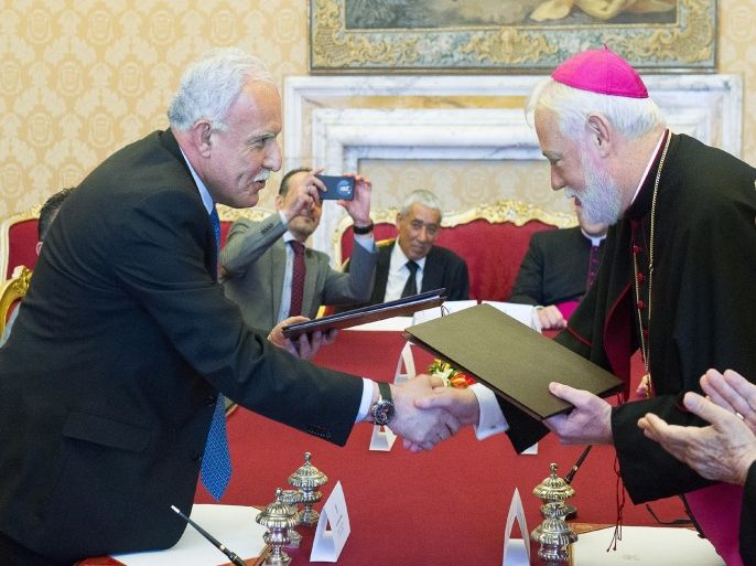 MON3004 - Vatican City, -, VATICAN CITY STATE : Vatican's State Relations secretary Paul Richard Gallagher (R) shakes hands with Palestinian Foreign minister Riad al-Malki after signing a Vatican-Palestine territories accord at the Vatican on June 26, 2015. The Vatican on June 26 signed a historic first accord with Palestine, two years after officially recognising it as a state. The accord, a treaty covering the activities of he Church in the parts of the Holy Land under Palestinian control, was the first since the Vatican recognised Palestine as a state in February 2013. The product of 15 years of discussions, the agreement was finalised in principle last month and bitterly condemned then by Israel as a setback for the peace process. AFP PHOTO / OSSERVATORE ROMANO