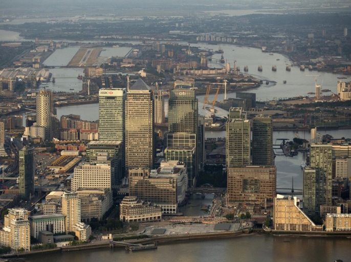 Skyscrapers in the Canary Wharf business, financial and shopping district, including HSBC Holdings Plc, center left, One Canada Square, center, and Citigroup Inc., are seen in this aerial photograph, as London City airport, far left, and the Thames Barrier, far right, are seen in the background in London, U.K., on Tuesday, June 16, 2015. Britain had its smallest budget deficit for any May since 2007 as tax income jumped, handing a boost to Chancellor of the Exchequer George Osborne as he prepares to unveil the first budget of the new Conservative-only government.