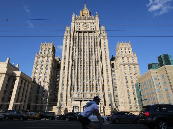 A cyclist and road traffic pass the offices of the Russian Ministry of Foreign Affairs in Moscow, Russia, on Monday, June 8, 2015. Rents in Moscow's most coveted neighborhoods are plunging as demand withers with the exodus of U.S. and European executives.