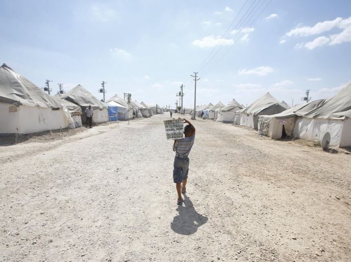 A Syrian refugee boy carries water at Suleymansah refugee camp in Akcakale in Sanliurfa province, Turkey, June 11, 2015. REUTERS/Osman Orsal