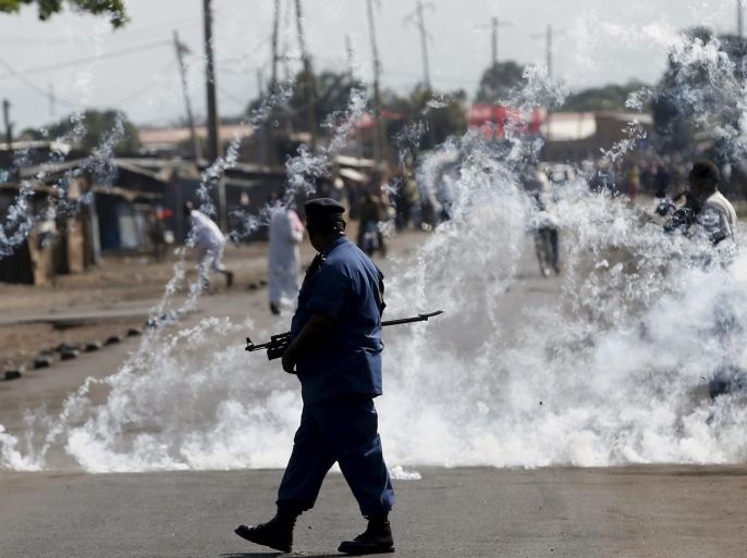 A policeman walks after throwing a teargas canister during a protest against Burundi President Pierre Nkurunziza and his bid for a third term in Bujumbura, Burundi, June 2, 2015. REUTERS/Goran Tomasevic