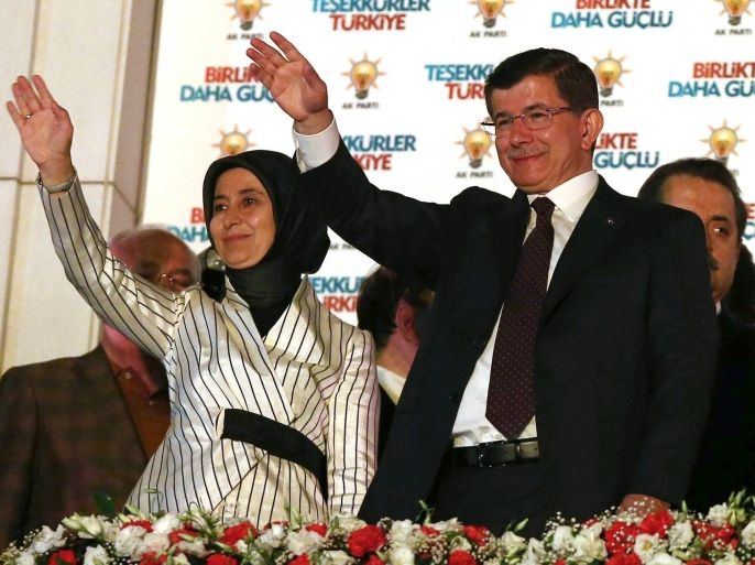 Turkish Prime Minister Ahmet Davutoglu (R) and his wife Sare wave towards supporters and militants of the Justice and Development Party (AKP) from the balcony of the Justice and Development Party headquarters, after the legislative elections in Ankara on June 7, 2015. Turkey's Islamic-rooted ruling party lost its parliamentary majority in the June 7 legislative elections, dealing a severe blow to strongman President Recep Tayyip Erdogan's ambition to expand his powers. AFP PHOTO/ADEM ALTAN