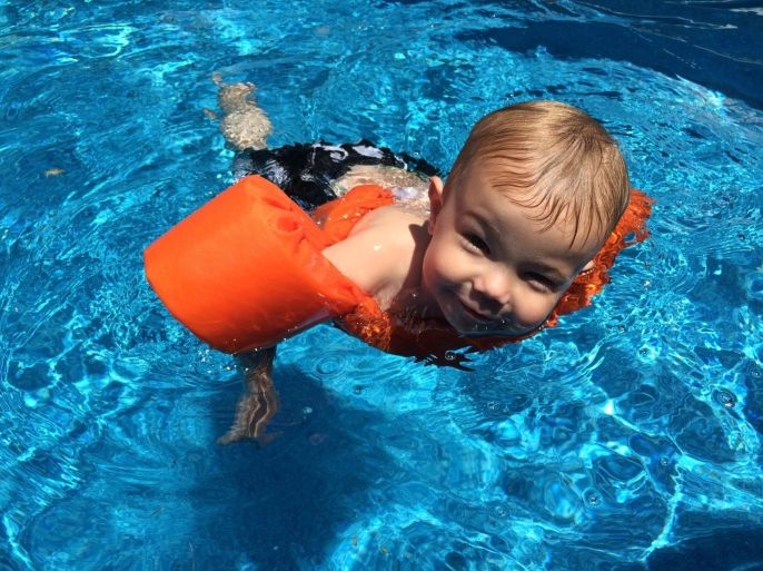 High Angle Portrait Of Smiling Boy Swimming In Pool