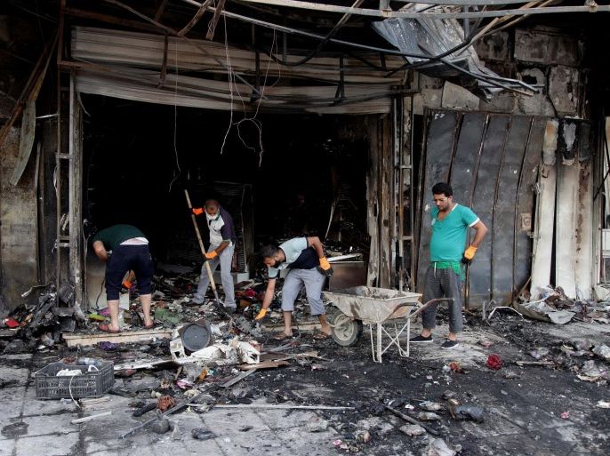 People try to clear damages at the scene a day after a car bombing hit the eastern neighborhood of New Baghdad, Iraq, Wednesday, July 22, 2015. On late Tuesday a car bomb detonated in front of a busy clothing store, killing and wounding civilians, officials said. (AP Photo/ Khalid Mohammed)