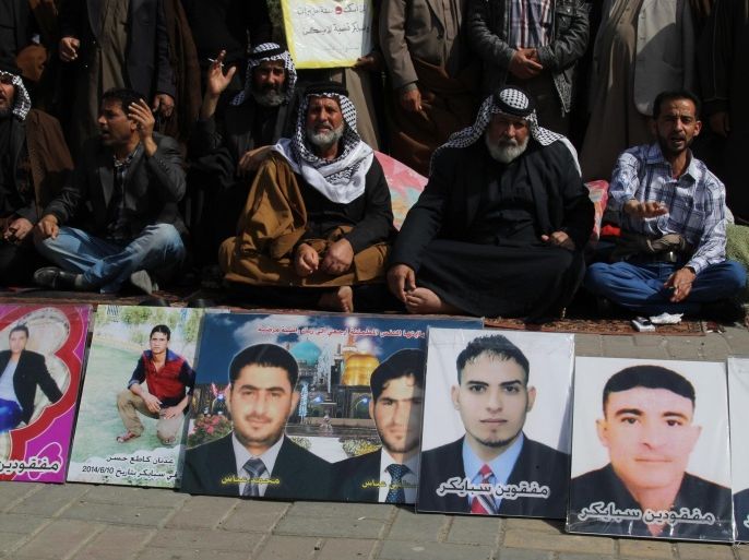 BAGHDAD, IRAQ - MARCH 9: Relatives hold the pictures of those who were murdered in Daesh attack on Spyker military base in Tikrit in last year's June, as a demonstration is staged for the 700 Spyker attack victims at Tahrir Square in Baghdad on March 9, 2015.