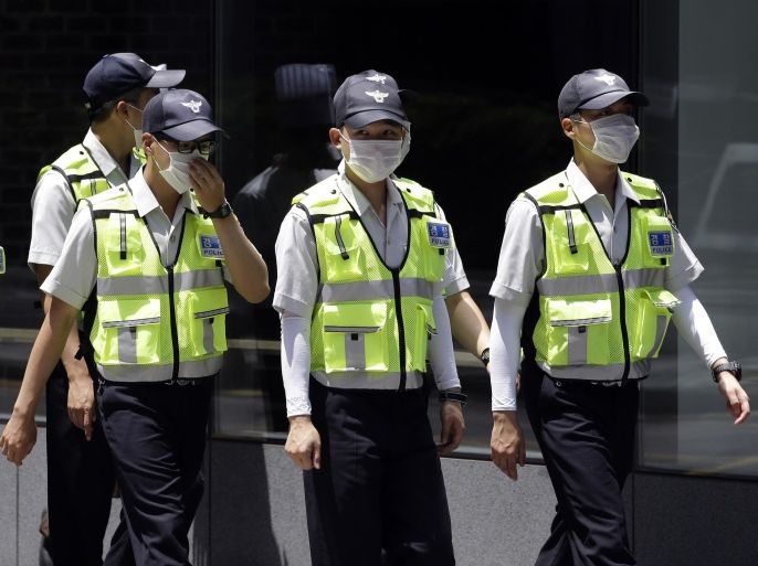 South Korean police officers wear masks as a precaution against MERS virus in downtown Seoul, South Korea Thursday, June 4, 2015. Sales of surgical masks surge amid fears of a deadly, poorly understood virus. The current frenzy in South Korea over MERS, which stands for Middle East Respiratory Syndrome, brings to mind the other menacing diseases to hit Asia over the last decade - SARS, which killed hundreds, and bird flu. (AP Photo/Lee Jin-man)