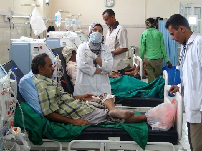 Yemeni medical staff members stand next to a patient at the Al-Sadaqa hospital in the port city of Aden, on May 21, 2015. Saudi-led coalition warplanes carried out fresh raids on rebel positions in southern Yemen as pro-government tribesmen advanced on Shiite Huthi strongholds in the north, according to tribal and army sources. AFP PHOTO / SALEH OBEIDI