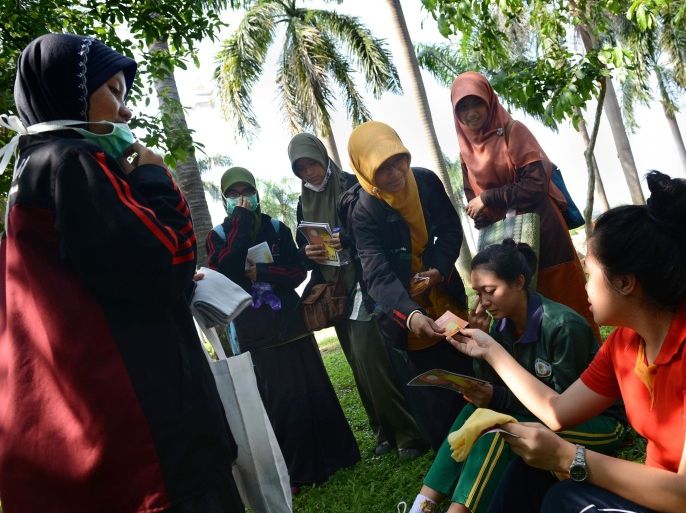 Indonesian students from different universities distribute 'hijabs' to women at the central National Monument park in Jakarta on February 10, 2013 during a campaign to promote the wearing of the hijab, a veil to cover the head as part of Islamic religious devotion for women. Indonesia is the world's most populous Muslim country, 90 percent of Indonesia's population of 240 million identify themselves as Muslim but the vast majority practise a moderate form of Islam.