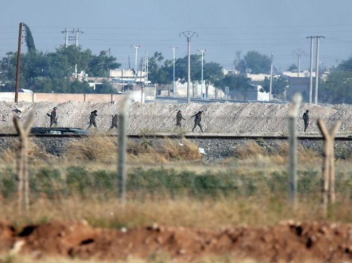 FILE-In this Monday, June 15, 2015 file photo taken from the Turkish side of the border between Turkey and Syria, in Akcakale, southeastern Turkey, showing Kurdish fighters with the Kurdish People's Protection Units, or YPG, advance in the outskirts of Tal Abyad, Syria. As Kurdish rebels in northern Syrian rack up wins against the Islamic State group, Turkey’s press is once again abuzz with talk of plans for a long-debated intervention aimed at pushing the radical religious group back from its border, and outflanking any Kurdish attempt at creating a state along Turkey’s southern frontier. (AP Photo/Lefteris Pitarakis, file)