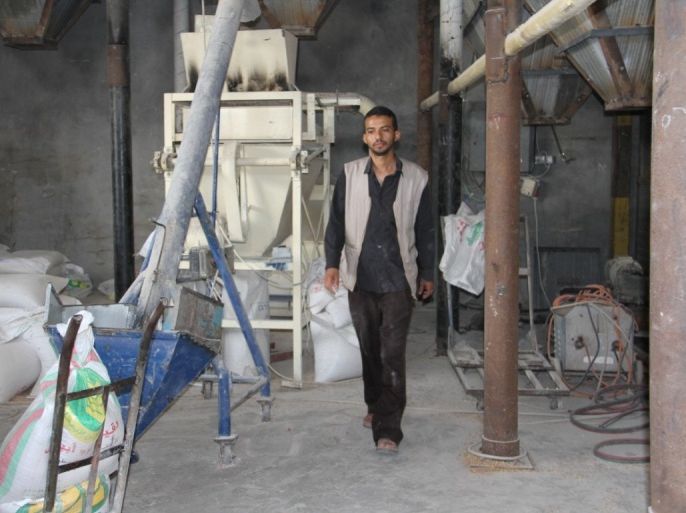 علاء أبو لحية يسير بالقرب من مطحنته المخصصة للحبوب والدقيق والمتعطلة بسبب تجدد أزمة الكهرباء