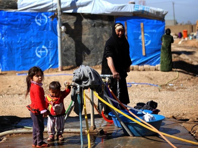 Displaced Iraqis, who fled their homes due to attacks by jihadists from the Islamic State (IS) group, wash their clothes at the Harsham refugee camp where they are taking shelter, ten kilometres west of Arbil, in the autonomous Kurdistan region of Iraq, on February 27, 2015. Some 900,000 internally displaced person's (IDP) have fled Iraq and found refuge in Kurdistan due to IS advances in the war-torn country. AFP PHOTO / SAFIN HAMED