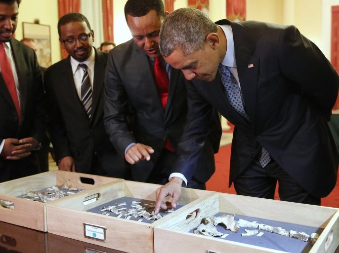 Dr. Zeresenay Alemseged Lemseged (2ndR), of the California Academy of Sciences, directs U.S. President Barack Obama (R) to touch a fossilized vertebra of Lucy, an early human, before a State Dinner in Obama's honor at the National Palace in Addis Ababa, Ethiopia July 27, 2015. Lucy is the most famous fossil of the species Australopithecus afarensis, and was found in Ethiopia in 1974. REUTERS/Jonathan Ernst
