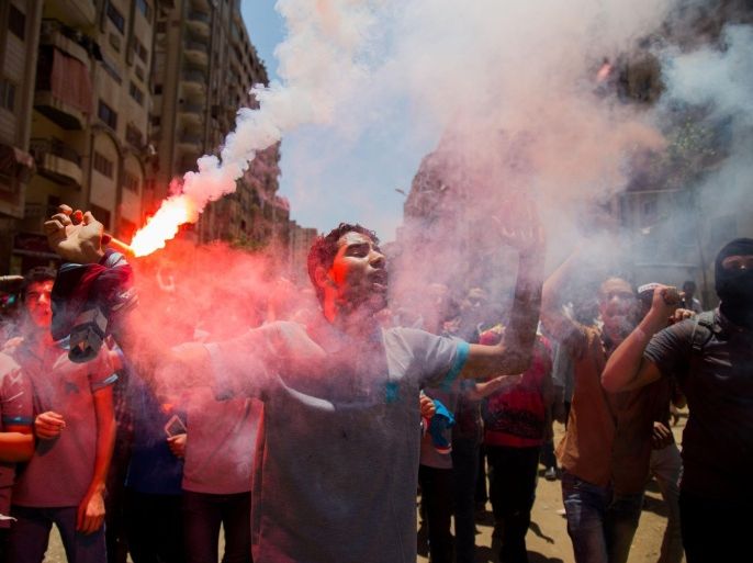 GIZA, EGYPT - JULY 3: Egyptians, who call themselves as an anti-coup group, shout slogans and light flares as they protest against the coup regime and the mass death sentence decisions including Egypt's former president Mohamed Morsi, in Giza, Egypt on July 3, 2015.