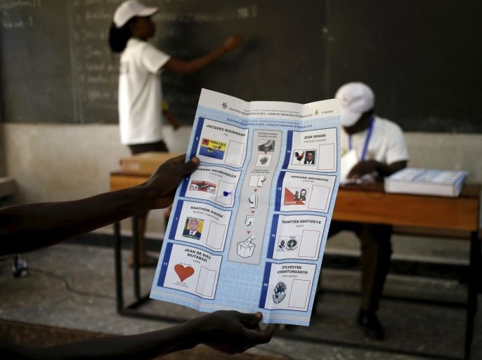 An election official holds up a ballot for scrutiny during vote counting for Burundi's presidential elections in the capital Bujumbura, July 21, 2015. At least one policeman and a civilian were killed in overnight violence before voting started, a presidential official said. REUTERS/Mike Hutchings