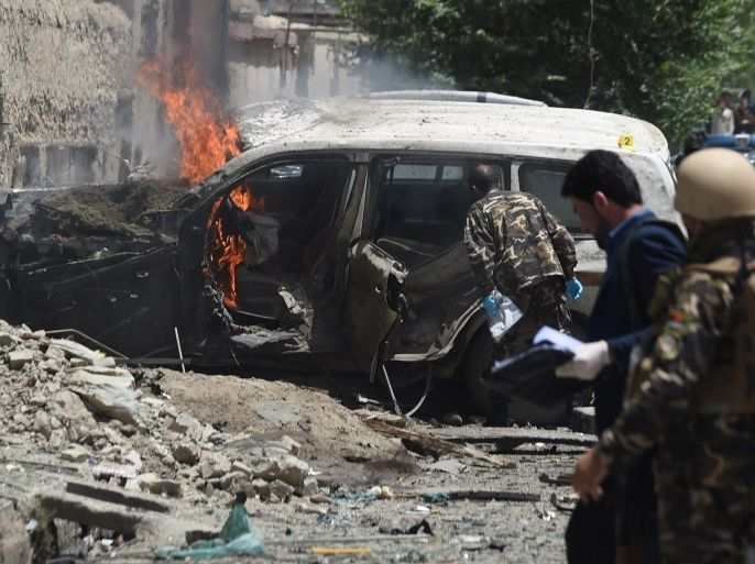 Afghan security forces inspects the damaged vehicle at the site of a suicide bomber that targeted NATO forces in Kabul on July 7, 2015. A Taliban suicide bomber targeted NATO forces in Kabul on July 7, officials said, as the Taliban step up attacks as part of their annual summer offensive. AFP PHOTO / SHAH Marai